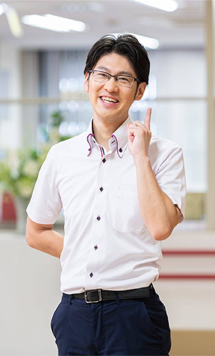 笑顔で指をさす白いシャツの男性